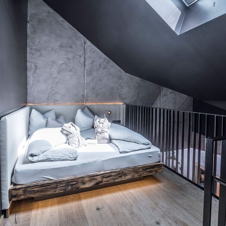Modernes Hoteldesign zeigt ein stilvolles Schlafzimmer mit gemütlicher Raumgestaltung und klaren Linien in alpiner Architektur.