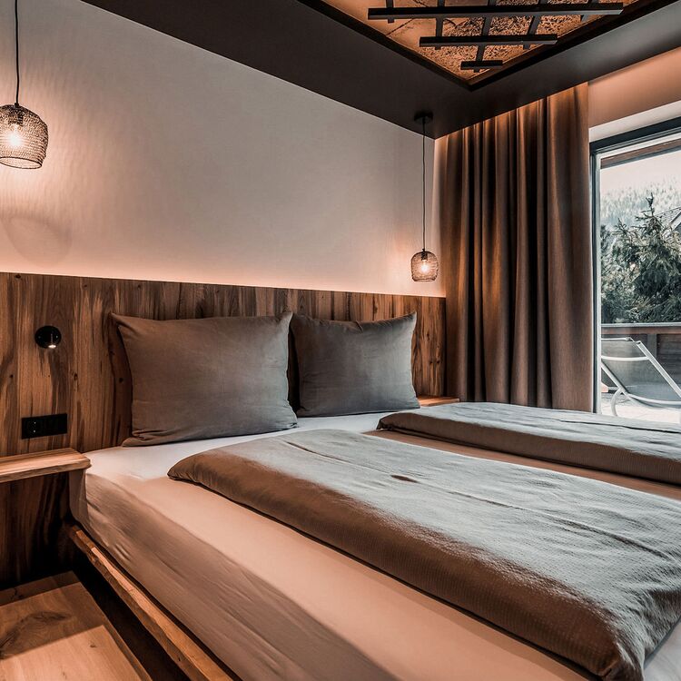 Ein modernes Schlafzimmer mit Holzdetails und sanften Farben bietet ein ideales Gästeerlebnis in der Hotelarchitektur.