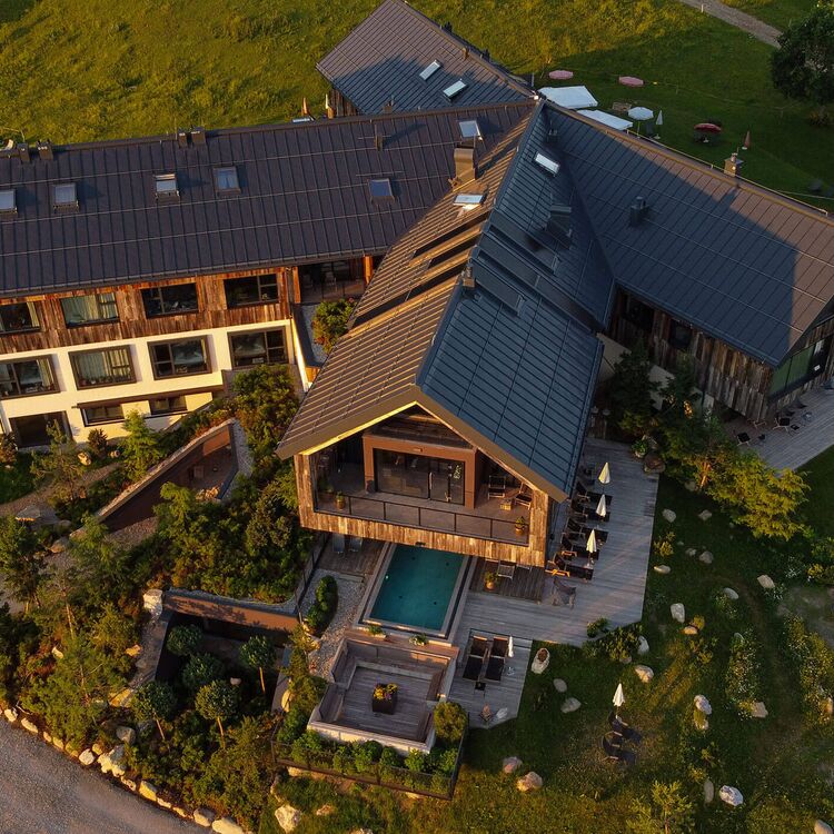 Moderne Hotelarchitektur umgeben von grüner Natur, ideal für Gästeerlebnisse und entspannende Aufenthalte.