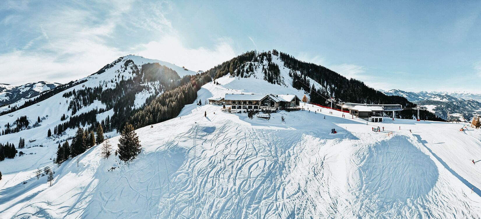 Alpine Architektur prägt das Gästeerlebnis in diesem charmanten Hotel in einer schneebedeckten Berglandschaft.