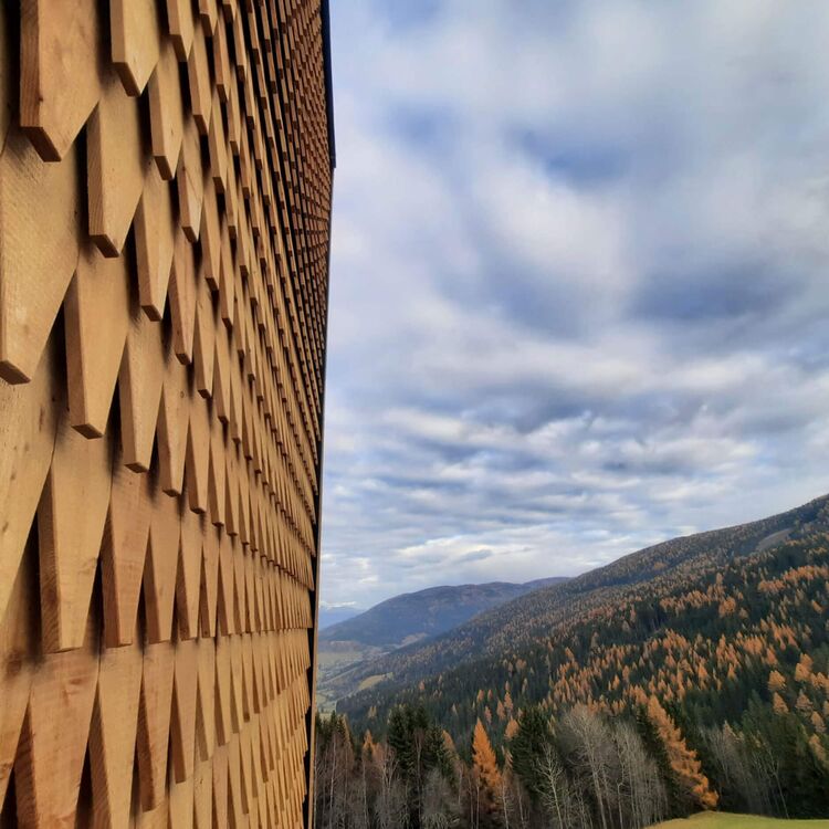 Die alpine Architektur des Hotels harmoniert perfekt mit der malerischen Landschaft der Berge und Wälder.
