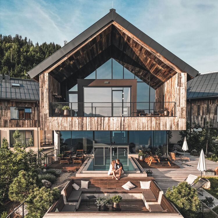 Moderne Hotelarchitektur vereint alpine Elemente mit einem einladenden Gästeerlebnis in dieser idyllischen Umgebung.