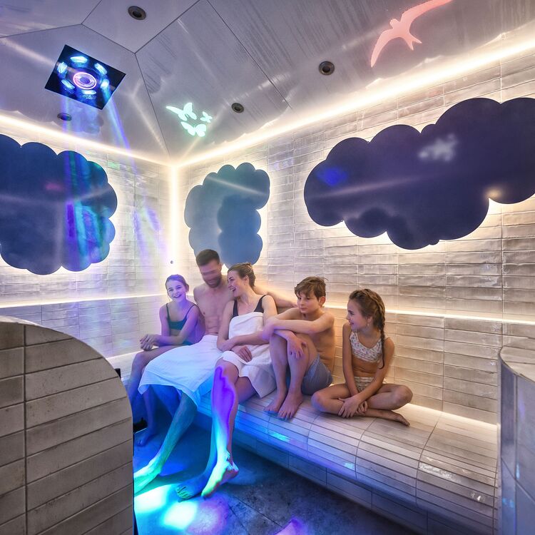 Eine Gruppe von Gästen genießt Entspannung in einem modernen Sauna-Bereich, gestaltet für ein optimales Gästeerlebnis.