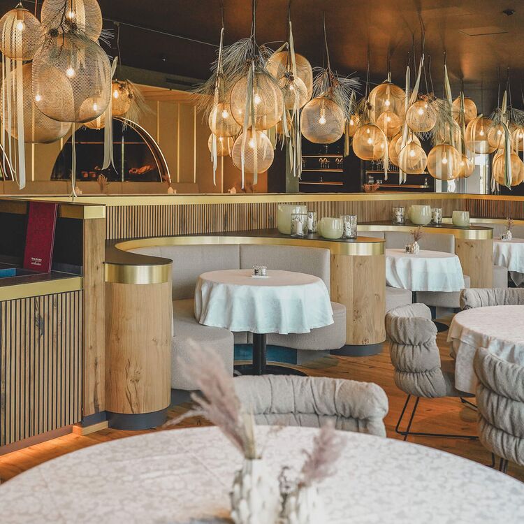 Elegante Innenarchitektur im Hotel Steiner mit stilvollen Tischen und einzigartigem Lichtdesign für ein tolles Gästeerlebnis.