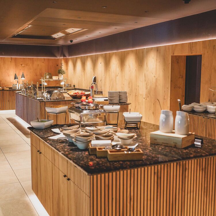 Elegante Innenarchitektur des Hotelrestaurants mit Holzakzenten und einem vielfältigen Buffet für ein unvergessliches Gästeerlebnis.