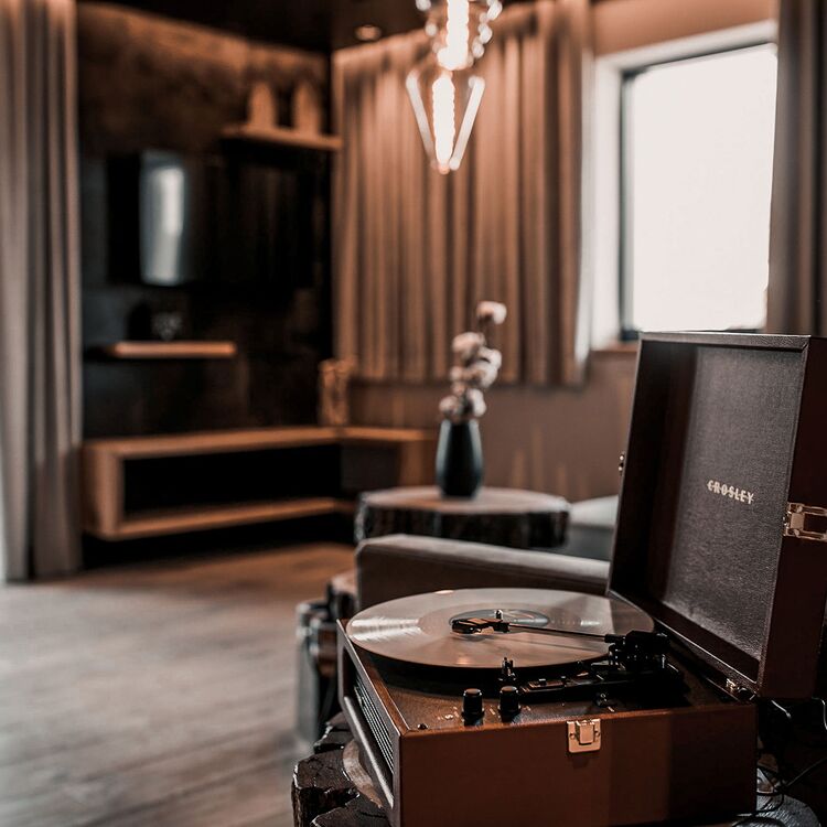 Ein stilvolles Hotelzimmer mit Plattenspieler, das modernes Hoteldesign und gemütliche Raumgestaltung vereint.