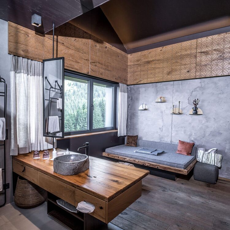 Ein modernes Badezimmer mit Holzdetails und Blick auf alpine Architektur für ein unvergessliches Gästeerlebnis.