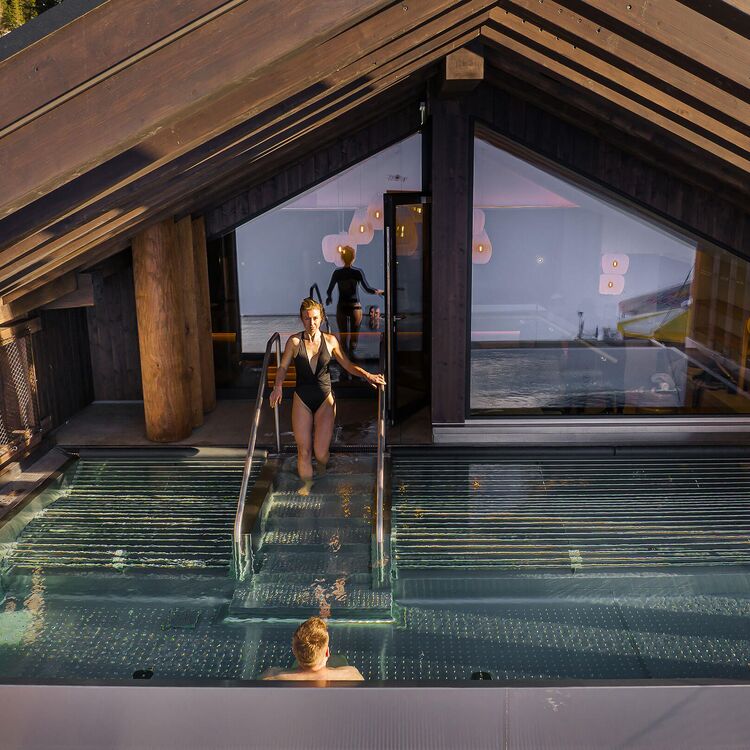 Ein modernes Hotel mit einem stilvollen Innenpool und alpenländischer Architektur bietet ein einzigartiges Gästeerlebnis.