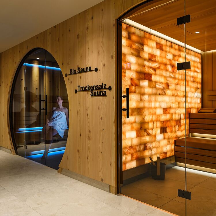 Moderne Hotelarchitektur zeigt eine elegante Sauna mit Holzdesign und Salzsteinwand für ein einzigartiges Gästeerlebnis.