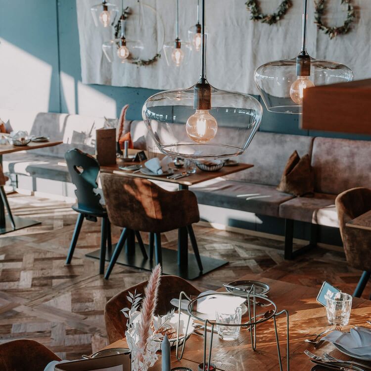 Elegante Innenarchitektur in einem Restaurant mit stilvollen Lampen und ansprechender Raumgestaltung für ein optimales Gästeerlebnis.