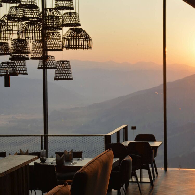Moderne Innenarchitektur eines Hotels mit spektakulärem Ausblick und stilvollem Mobiliar bei Sonnenuntergang.