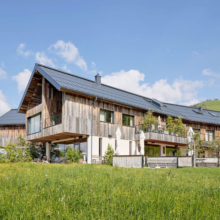 Moderne Hotelarchitektur kombiniert alpine Elemente und schafft ein einladendes Gästeerlebnis in der Natur.