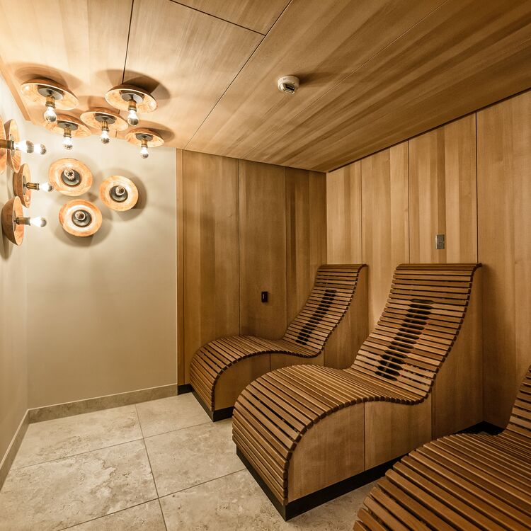 Der entspannende Ruheraum zeigt moderne Innenarchitektur mit Holz und stilvollen Liegen für ein perfektes Gästeerlebnis.