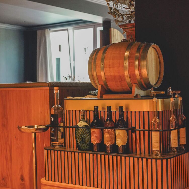 Elegante Hotelarchitektur mit einem stilvollen Barbereich und einer Auswahl an feinen Getränken im Restaurant.