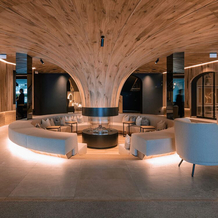 Moderne Hotelarchitektur mit elegantem Innenraum und gemütlichen Sitzbereichen für ein angenehmes Gästeerlebnis.
