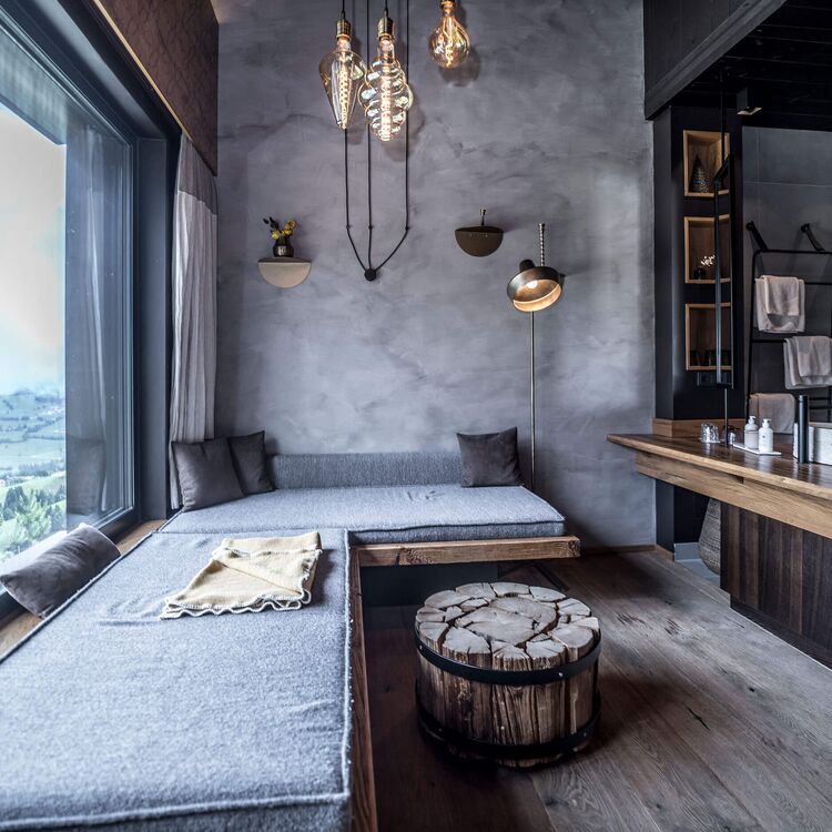 Modernes Hoteldesign mit alpiner Architektur, gemütlicher Sitzgelegenheit und Aussicht auf die umliegenden Berge.
