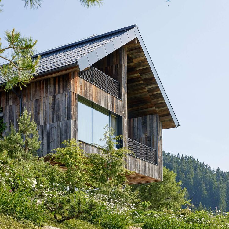 Modern alpine Architektur kombiniert Holz und Glas für ein einzigartiges Hotelkonzept in der Natur.