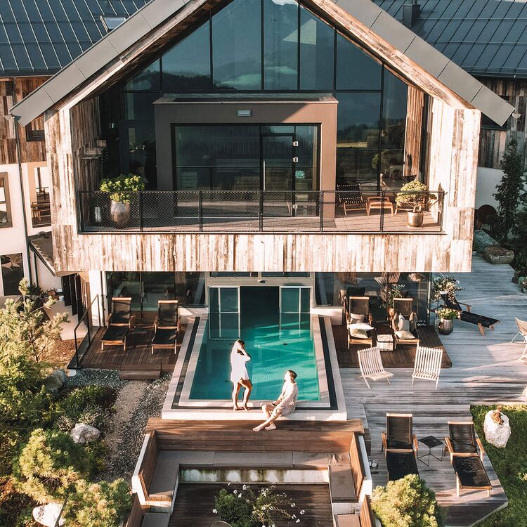Moderne Hotelarchitektur mit Schwimmbad und gemütlichen Außenbereichen für ein unvergessliches Gästeerlebnis in den Alpen.